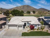 Inviting single-story home showcasing a pristine tiled roof, neat landscaping, and a backdrop of scenic mountains at 6340 W Donald Dr, Glendale, AZ 85310