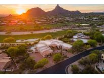 Aerial view of luxury home with a pool, tile roof, and desert landscaping backing up to mountains at 10596 E Yearling Dr, Scottsdale, AZ 85255
