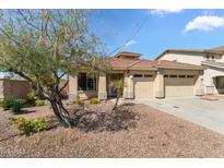 Charming single-story home with a well-manicured front yard and a three-car garage at 14694 W Mandalay Ln, Surprise, AZ 85379