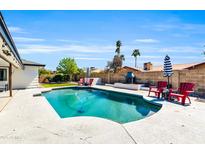 Inviting pool surrounded by a spacious patio, outdoor furniture, and a built-in grill at 1607 E Gable Ave, Mesa, AZ 85204