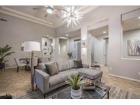Inviting living room featuring a modern gray sofa, striking light fixture, and elegant decor at 33601 N 64Th St, Scottsdale, AZ 85266
