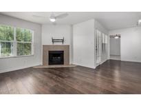 Bright living room features a fireplace, ceiling fan, and wood flooring at 8787 E Mountain View Rd # 2021, Scottsdale, AZ 85258