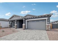 Charming single-Gathering home showcasing a gray exterior, brick accents, and a paved driveway at 11432 E Utopia Ave, Mesa, AZ 85212