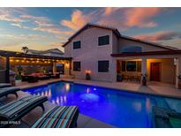 Inviting backyard pool with lounge chairs and covered patio, perfect for outdoor entertaining at 16021 W Sherman St, Goodyear, AZ 85338