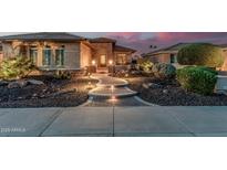 Charming front yard featuring a paved walkway, desert landscaping, and exterior lighting at 16422 W Alvarado Dr, Goodyear, AZ 85395