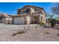 Charming two-story home with a neutral-colored exterior, low-maintenance landscaping, and attached two-car garage at 1673 S 218Th Ave, Buckeye, AZ 85326