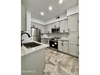 Modern kitchen boasts stainless steel appliances, light grey cabinets, and stylish countertops at 1701 E Colter St # 102, Phoenix, AZ 85016