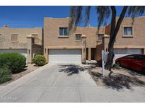 Home exterior features a 2-car garage and desert-style landscaping in a community of attached homes at 2912 E Eberle Ln, Phoenix, AZ 85032
