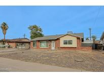 Charming single-story brick home featuring a well-lit entry and low-maintenance gravel landscaping at 4238 W Krall St, Phoenix, AZ 85019