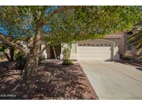 Tan home with a well manicured front yard and a two-car garage at 45140 W Zion Rd, Maricopa, AZ 85139
