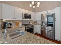 Bright kitchen featuring stainless steel appliances, granite countertops, white cabinets, and a modern chandelier at 927 W Wendy Way, Gilbert, AZ 85233