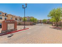 Community entrance with brick-paved road and a welcoming sign on a sunny day at 14575 W Mountain View Blvd # 10313, Surprise, AZ 85374
