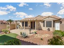 Well-maintained backyard featuring a covered patio, desert landscaping, and artificial turf area at 16160 W Starlight Dr, Surprise, AZ 85374