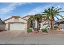 Charming single-story home features a two-car garage, stucco exterior, and desert landscaping with palm trees at 17806 N Becke Ln, Surprise, AZ 85374