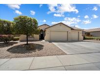 Charming home featuring a three-car garage, lush landscaping, and neutral color palette at 18237 W Port Au Prince Ln, Surprise, AZ 85388