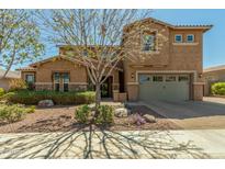 Charming two-story home boasts a well-manicured front yard and inviting curb appeal at 18483 W Paradise Ln, Surprise, AZ 85388