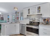 Well-lit kitchen featuring white cabinetry, stainless steel appliances, and modern fixtures at 201 S Greenfield Rd # 255, Mesa, AZ 85206