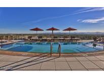 Rooftop pool featuring lounge chairs, sun umbrellas, and scenic views of the surrounding cityscape at 2211 E Camelback Rd # 604, Phoenix, AZ 85016