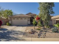 Charming single-story home showcasing a desert landscape, tile roof, and a two-car garage at 4415 W Ellis St, Laveen, AZ 85339