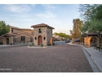 Elegant gated community entrance with stone guard house and manicured landscaping at 5641 E Grovers Ave, Scottsdale, AZ 85254