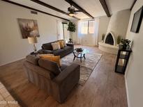 Inviting living room features beamed ceilings, a unique fireplace, and comfortable seating at 7843 E Valley View Rd, Scottsdale, AZ 85250