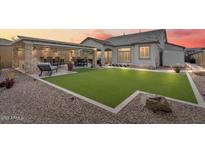 Enjoy this home's backyard with an outdoor kitchen, synthetic grass, and ample space for dining and entertaining at 8154 E Jaeger St, Mesa, AZ 85207