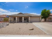 Charming single-story home featuring a desert landscape, covered porch, and attached two-car garage at 10001 W Potter Dr, Peoria, AZ 85382