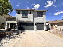 Two-story home featuring a double garage, gray stucco, and concrete driveway under a clear blue sky at 2972 W South Butte Rd, San Tan Valley, AZ 85144