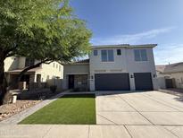 Two-story home featuring an attached two-car garage, a low maintenance lawn, and mature shade tree at 2972 W South Butte Rd, San Tan Valley, AZ 85144