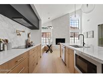Modern kitchen featuring white marble backsplash, wooden cabinets, and stainless steel appliances at 7624 E Larkspur Dr, Scottsdale, AZ 85260