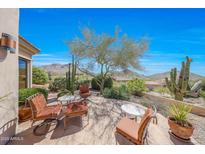Relaxing back patio with mountain views, desert plants, and comfortable seating area under a bright blue Arizona sky at 11099 E Desert Vista Dr, Scottsdale, AZ 85255