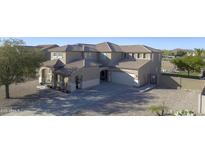 View of a beige two-story home featuring a tile roof, an attached two-car garage, and a well-maintained front yard at 31918 N Caspian Way, San Tan Valley, AZ 85143