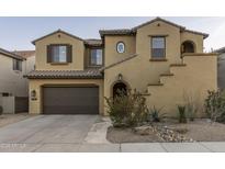 Charming two-story home showcasing a brown two-car garage and beautiful desert landscaping at 3911 E Rockingham Rd, Phoenix, AZ 85050
