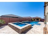 Beautiful pool with a built-in spa, and a covered outdoor living area in the backyard at 45975 W Mountain View Rd, Maricopa, AZ 85139