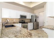 Modern kitchen features stainless steel appliances, granite countertops, and white cabinetry at 10316 E Rimrock Loop, Gold Canyon, AZ 85118