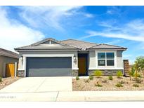 Charming single-story home featuring a two-car garage, stone accents, and low maintenance desert landscaping at 1706 N Camden Dr, Florence, AZ 85132