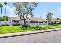 Well-maintained single-story home with lush lawn, mature trees, and manicured landscaping at 2017 W Edgemont Ave, Phoenix, AZ 85009