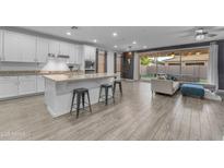 Modern kitchen with white cabinets, granite countertops, and stainless steel appliances open to the living area at 3938 E Ficus Way, Gilbert, AZ 85298