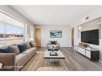 Bright living room with hardwood floors and a comfortable sofa with stylish blue pillows at 5455 E Baltimore St, Mesa, AZ 85205