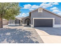 Charming single-story home with a two-car garage and a low-maintenance desert landscape in the front yard at 1165 E Avenida Kino --, Casa Grande, AZ 85122