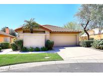 Inviting home exterior features a two-car garage, tile roof, desert landscaping, and mature shade trees at 13390 N 95Th Way, Scottsdale, AZ 85260