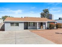 Charming single-story home featuring grey brick, a brown roof, and a spacious driveway at 1624 W Thomas Rd, Phoenix, AZ 85015