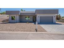 Modern single-story home featuring a gray stucco exterior, desert landscaping, and a two-car garage at 16405 N Cobblestone Ln, Fountain Hills, AZ 85268