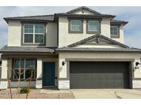 Charming two-story home featuring a gray two-car garage and a blue front door at 17808 W Sanna St, Waddell, AZ 85355