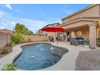 Inviting backyard features a sparkling pool with water features, patio, and barbecue at 18460 E Peachtree Blvd, Queen Creek, AZ 85142