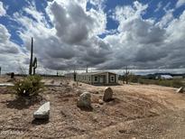 Expansive single-story home on large lot featuring mature desert landscaping and bright natural light at 25958 W Muirfield Dr, Morristown, AZ 85342