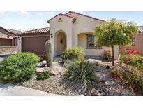 Charming front exterior with desert landscaping and arched entryway, showcasing a well-maintained and inviting facade at 27391 W Wahalla Ln, Buckeye, AZ 85396