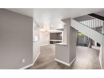 Bright, open-concept living room with wood floors and a modern lighting fixture at 3030 N Hayden Rd # 16, Scottsdale, AZ 85251