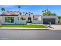 Stunning single-story home featuring lush green lawn, tile roof, and unique architectural details at 9627 E Gold Dust Ave, Scottsdale, AZ 85258