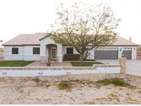 Charming single-story home with a tile roof, three-car garage, and landscaped front yard at 9732 N Penworth Dr, Casa Grande, AZ 85122